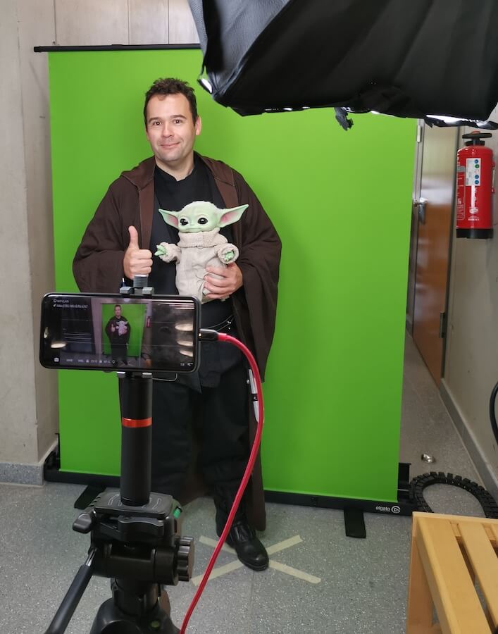 Besucher in Jedi-Gewandung mit Grogu-Figur vor dem Greenscreen des ivfsf e.V. beim #awc23 Andere Welten Con in Apensen